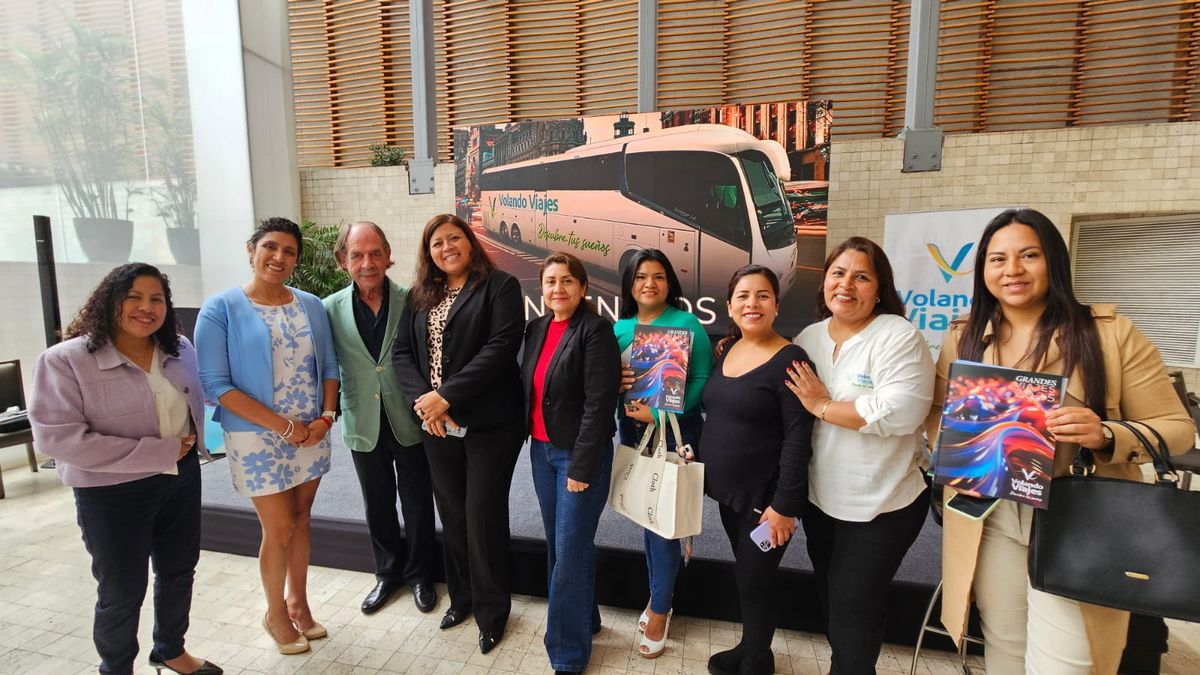 Las agentes de viajes posando con el manual grandes viajes 2025.