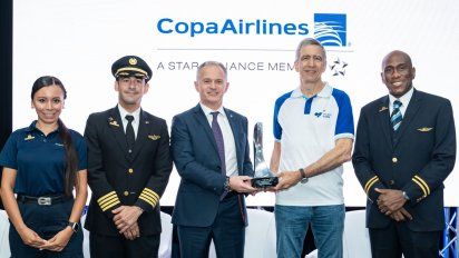 Jeremy Bowen, CEO de Cirium (centro a la izquierda) entrega la distinción de Pedro Heilbron, CEO de Copa Airlines (centro a la derecha), rodeados de tripulantes de la aerolínea.