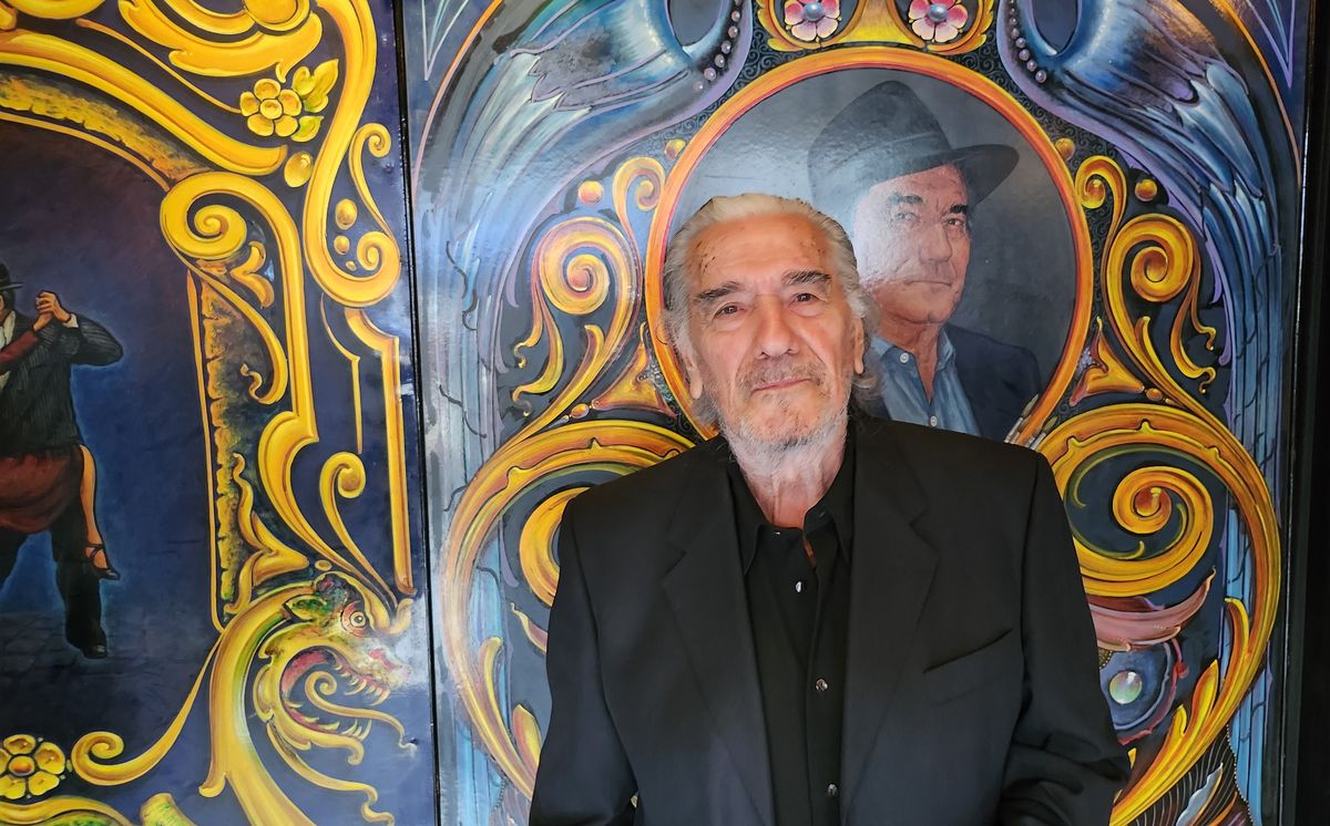 Martiniano Arce en la entrada de Michelangelo Legend, con uno de sus trabajos como telón de fondo.