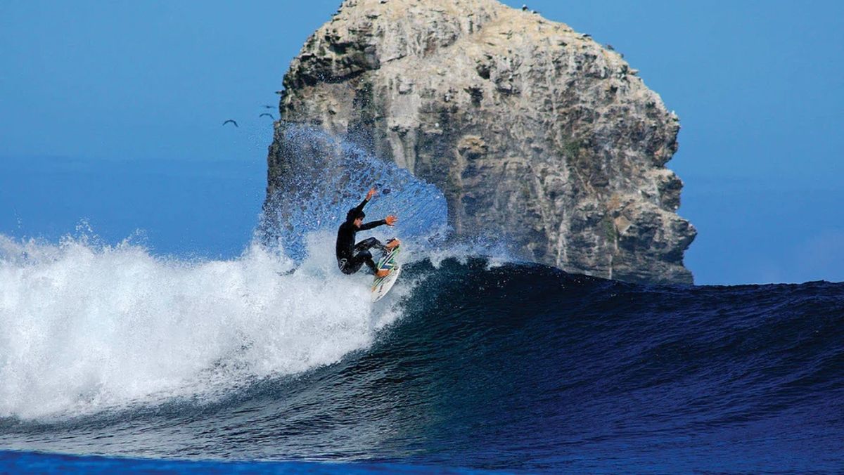 Surfistas en Punta de Lobos, reconocido como uno de los mejores destinos de surf del país, con olas potentes y acantilados espectaculares.
