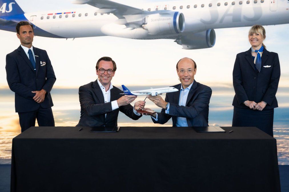 Arjan Meijer, presidente y director ejecutivo de Embraer Commercial Aviation, le entrega una maqueta del avión elegido a Anko van der Werff, presidente y CEO