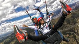 Dos turistas disfrutan de la aventura de los parapentes en Quito