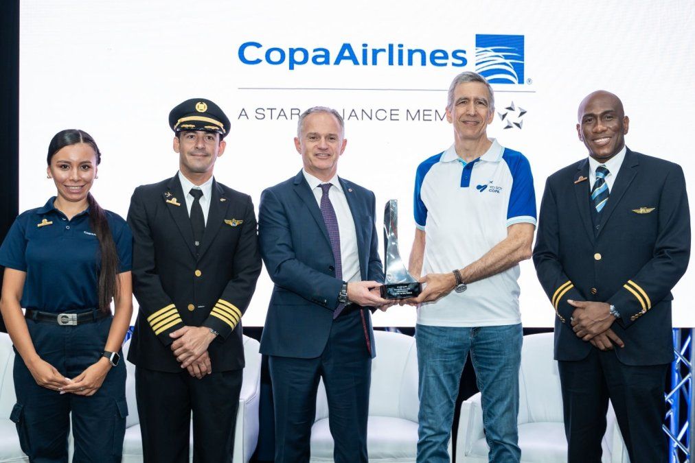 Jeremy Bowen, CEO de Cirium (centro a la izquierda) entrega la distinción de Pedro Heilbron, CEO de Copa Airlines (centro a la derecha), rodeados de tripulantes de la aerolínea. - Ladevi Medios y Soluciones Jeremy Bowen, CEO de Cirium (centro a la izquierda) entrega la distinción de Pedro Heilbron, CEO de Copa Airlines (centro a la derecha), rodeados de tripulantes de la aerolínea.