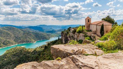 En la cima de un acantilado de paredes verticales de 730 metros de altura y con espectaculares vistas desde cualquier rincón, Siurana reposa entre las aguas del emblemático pantano del mismo nombre, la Sierra del Montsant y las montañas de Prades.