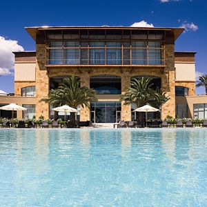 Pileta exterior con la imponente fachada trasera del Sofitel La Reserva Cardales