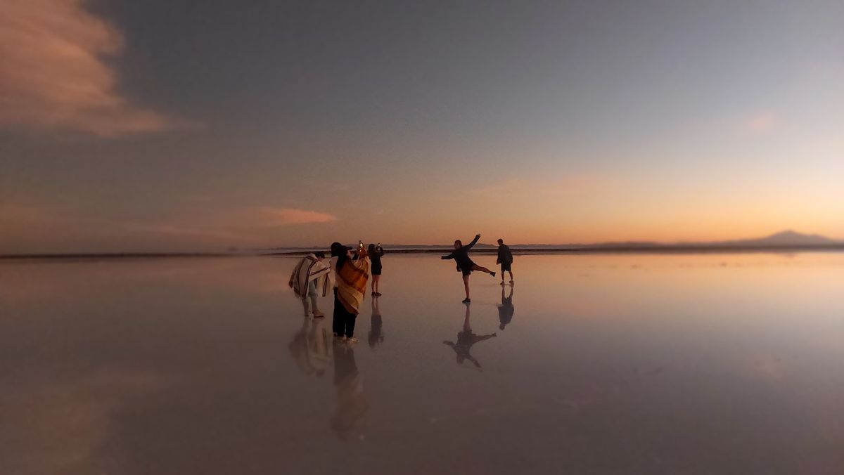Viajeros capturando momentos en el salar de Uyuni, en pleno sunset.