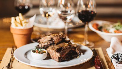 El menú criollo consiste en variedad de cortes de carne y vinos, empanadas, chorizo y morcilla.