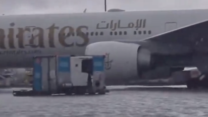 Avión de Emirates en medio de la pista totalmente inundada. Avión de Emirates en medio de la pista totalmente inundada.