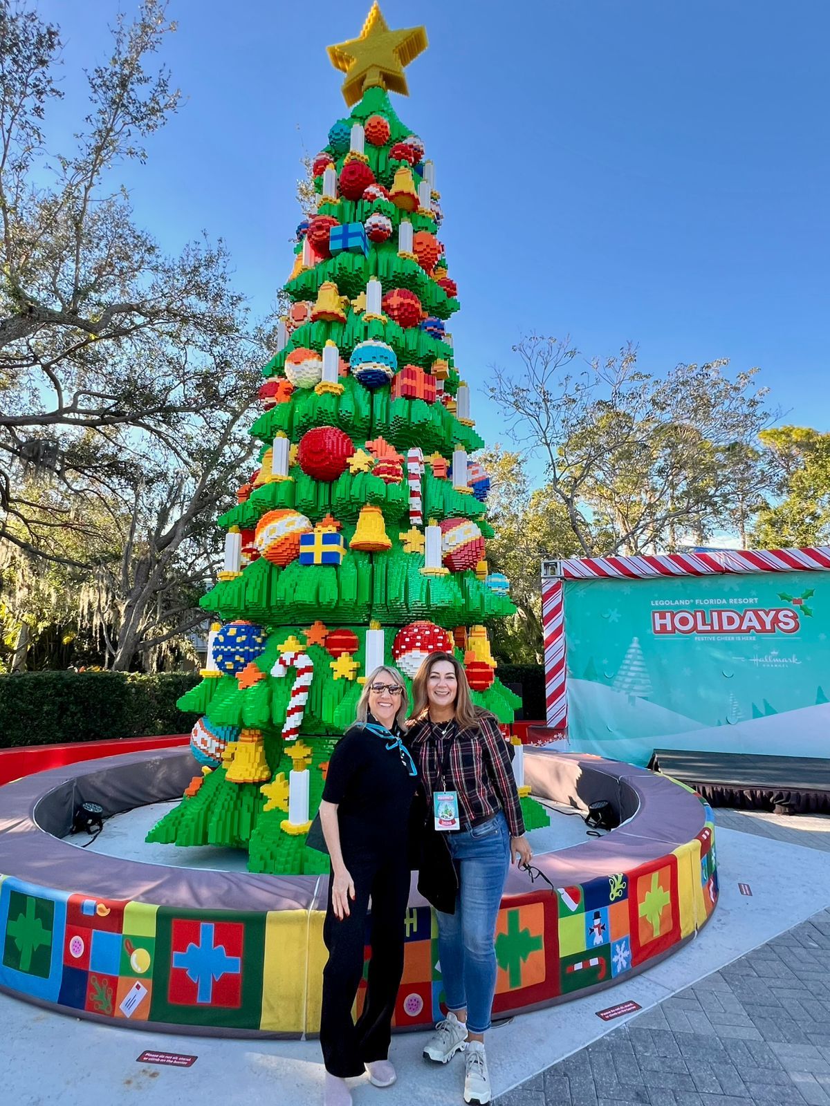 Claudia González, directora Comercial de Ladevi, junto a Mariale Ojeda, Hotel and Trade Sales Manager de Legoland Resorts North America, en el árbol de Navidad de Legoland Florida Resort.