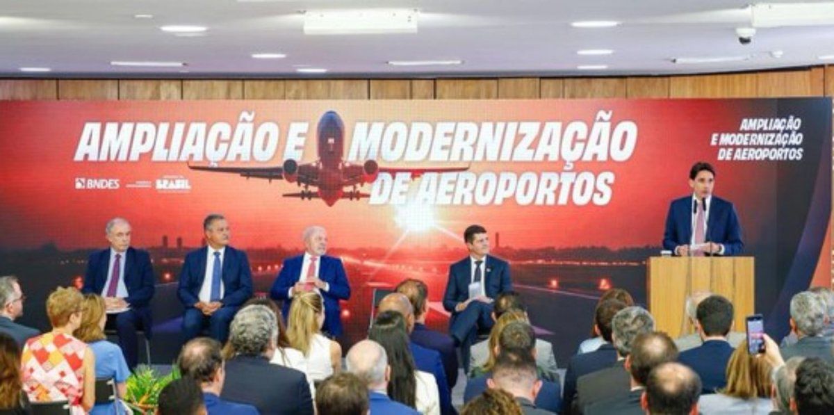 La presentación del plan de inversiones de Aena Brasil en el Palacio Planalto. En el uso de la palabra en el estrado, el ministro de Puertos y Aeropuertos, Silvio Costa Filho. En el centro del escenario, justo bajo el avión, el presidente de Brasil, Ignacio Lula da Silva.