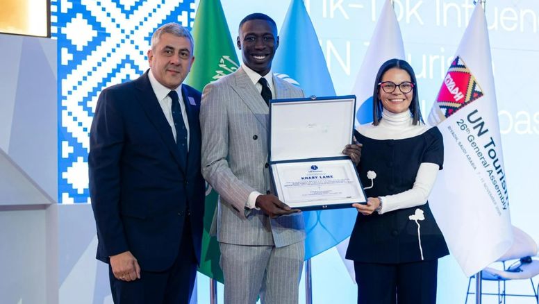 El ahora Embajador de ONU Turismo, Khaby Lame, posa con su placa junto a Zurab Pololikashvilie, exsecretario general de ONU Turismo; y Natalia Bayona, directora ejecutiva del organismo multilateral.
