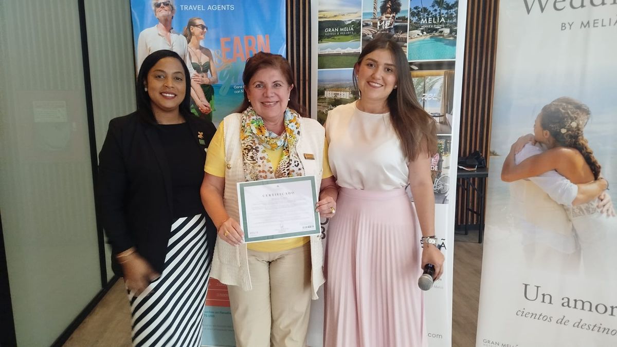 Heinicy Santana y Catalina Londoño entregando premio a una agente de viajes.