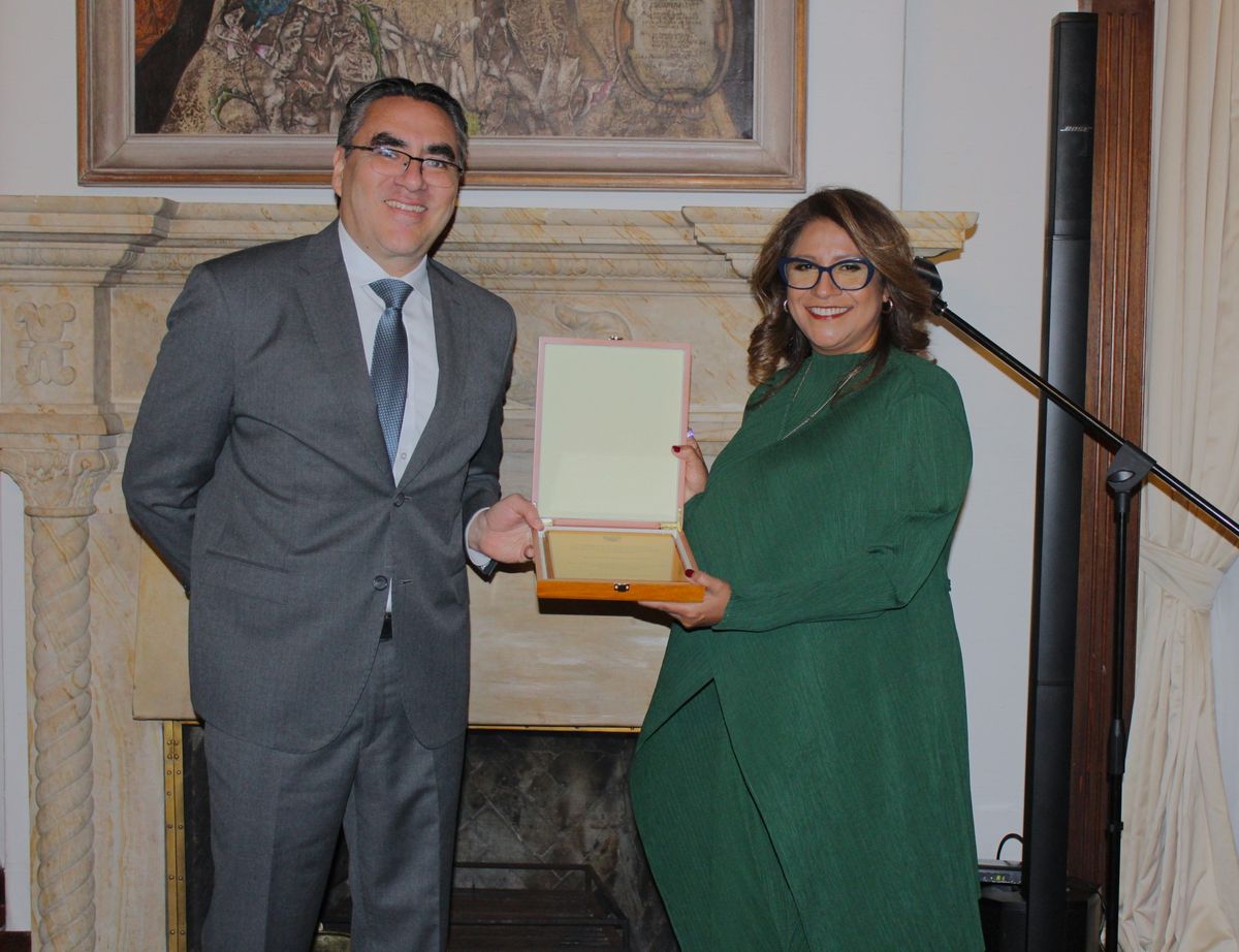 Mariano López, encargado de negocios y jefe de la Misión Diplomática de Perú en Colombia hace entrega a Soledad Campos del reconocimiento por su labor en la Embajada de Perú.&nbsp;
