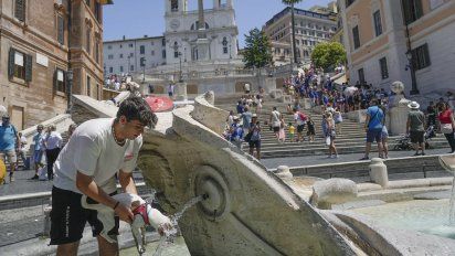 Turistas se refugian del calor en fuentes y con sus paraguas en Roma