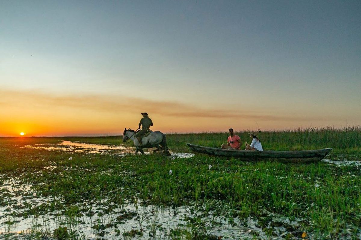 Las canoas conducidas por gauchos a caballo son una tradición de Iberá.   