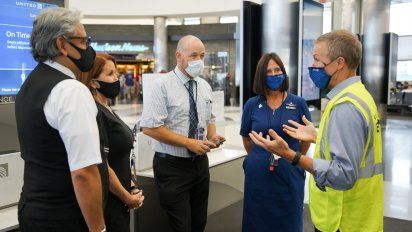 Scott Kirby, CEO de United, a la derecha, dialogando con un grupo de empleados.