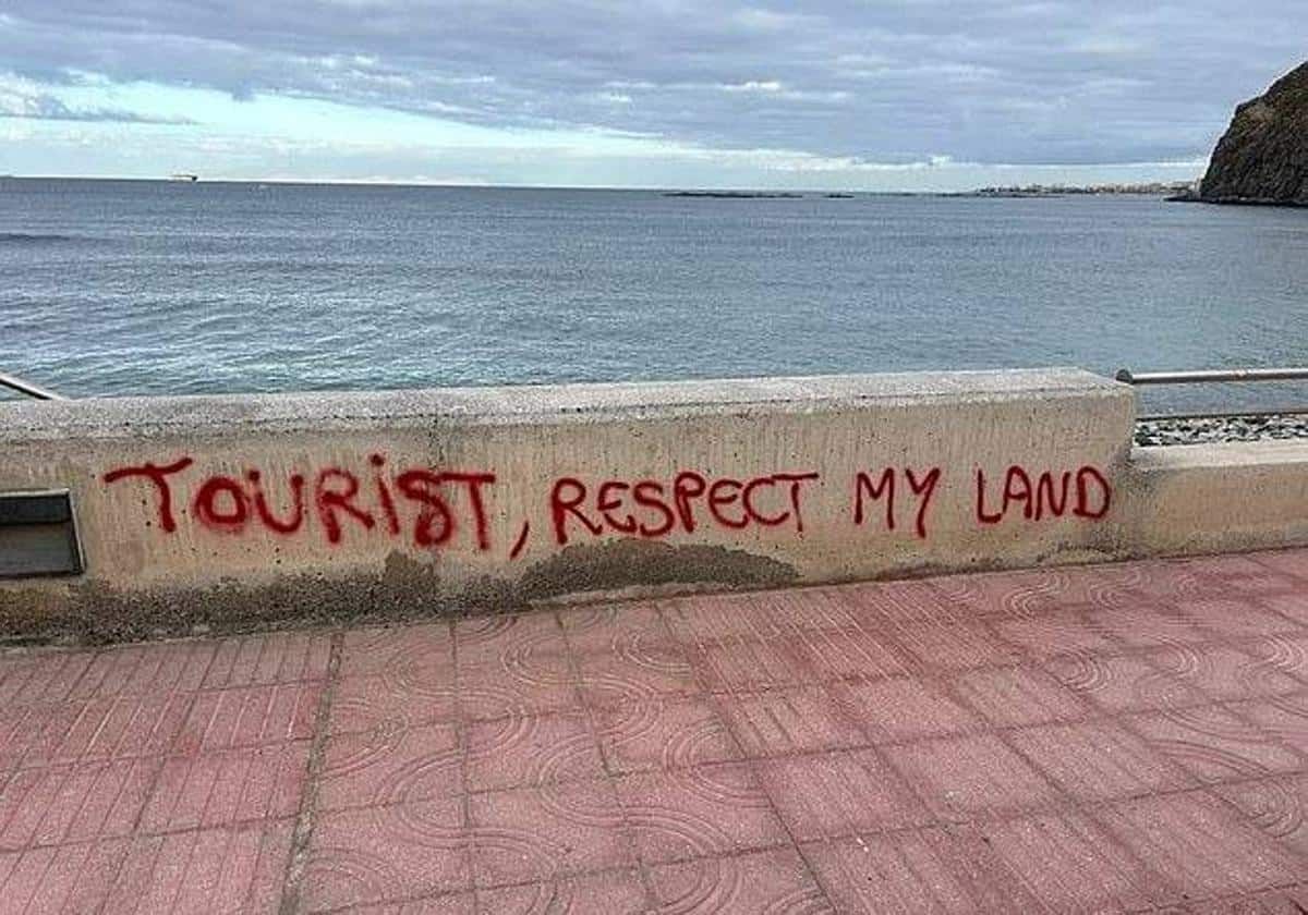 Pintada en contra del turismo en una de las playas de Tenerife, en las Islas Canarias. Pintada en contra del turismo en una de las playas de Tenerife, en las Islas Canarias.