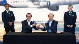 Arjan Meijer, presidente y director ejecutivo de Embraer Commercial Aviation, le entrega una maqueta del avión elegido a Anko van der Werff, presidente y CEO