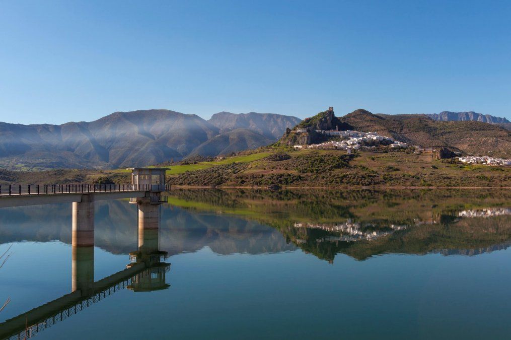 Destellos sueltos de verdes, marrones y blancos pintan el paisaje que forma el embalse Zahara-El Gastor al pie de este pueblo gaditano.