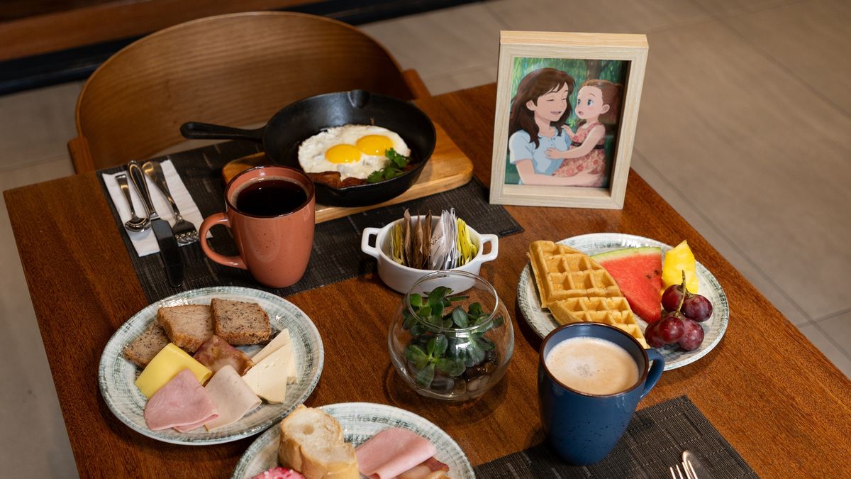 Desayuno buffet con diversidad de jugos, frutas, chicharrones y waffles con toppings variados.