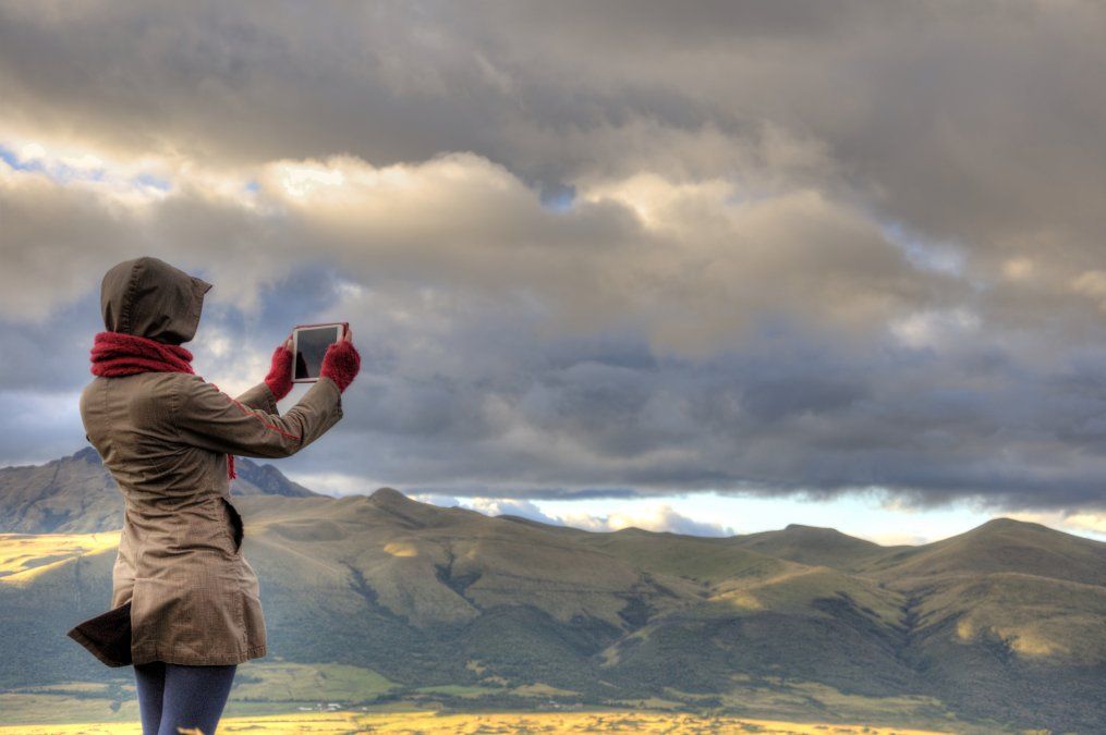 Turista fotografiando uno de los muchos volcanes de Quito.